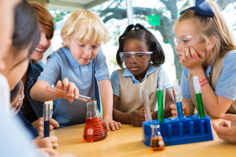 Elementary school students doing chemistry science experiment in class ...